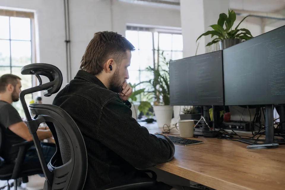 Zespół programistów przy biurkach w biurze spółki technologicznej
